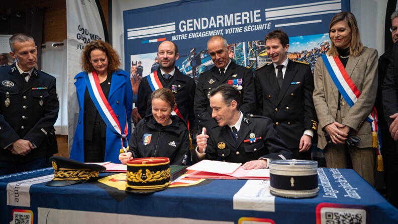 Au milieu d'autres gendarmes dont un colonel, Gaëlle Edon signe sur une table gendarmerie, le papier qui acte son lien avec le groupement de gendarmerie de la Haute-Savoie.