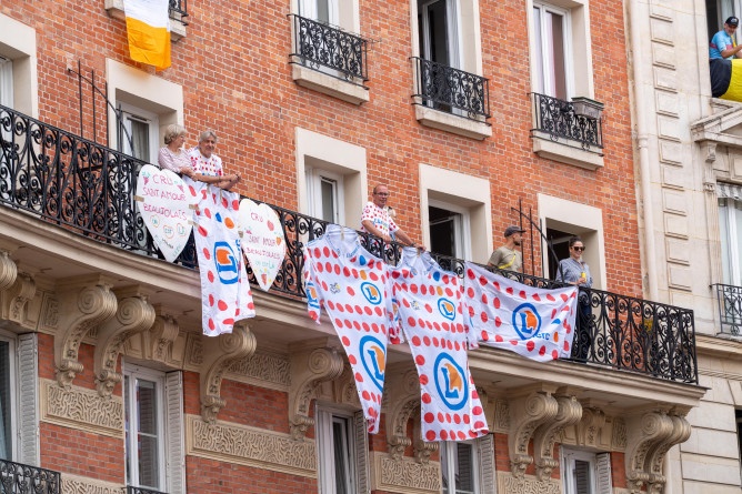 Agrandir l'image photo de parisiens à leur balcon, étendant des banderoles Leclerc, lors du passage du peloton du Tour de France