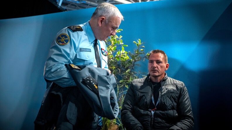 Le directeur g&eacute;n&eacute;ral de la gendarmerie nationale se tient debout aux c&ocirc;t&eacute;s de Franck Robin. Ce dernier est assis en fauteuil roulant. La sc&egrave;ne se d&eacute;roule en int&eacute;rieur, au salon des maires.