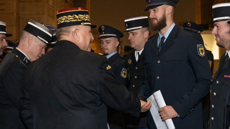 un g&eacute;n&eacute;ral de gendarmerie serre la main d'un policier allemand, entour&eacute; de plusieurs de ses coll&egrave;gues et de gendarmes fran&ccedil;ais