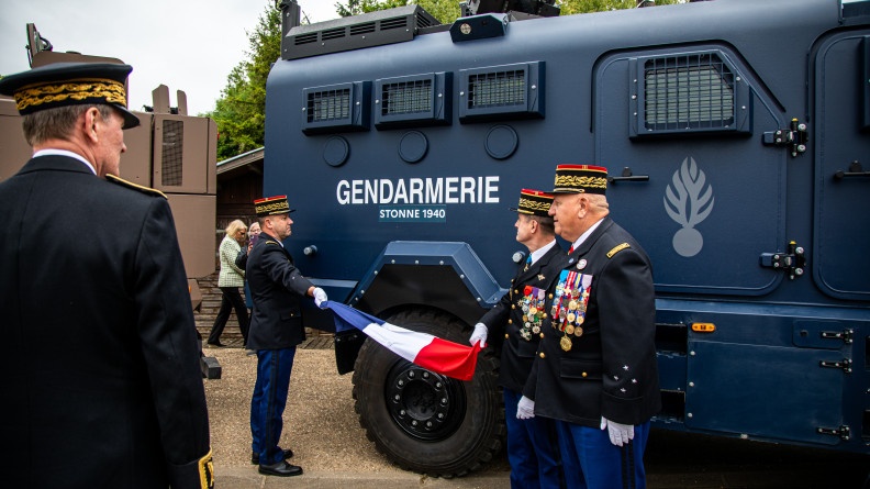 Deux g&eacute;n&eacute;raux &ocirc;tent un drapeau appos&eacute; sur un v&eacute;hicule Centaure d&eacute;voilant son nom de bapt&ecirc;me "Stonne 1940".