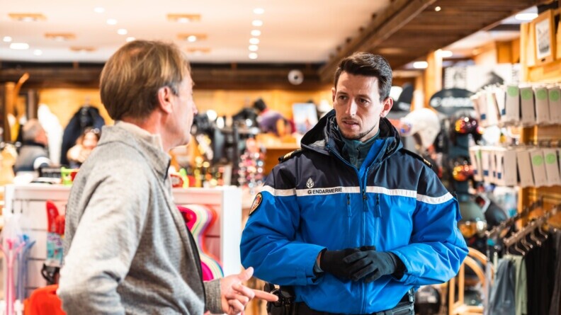 Agrandir l'image Un gendarme de la brigade de Val d'Isère échange avec un commerçant de la station.