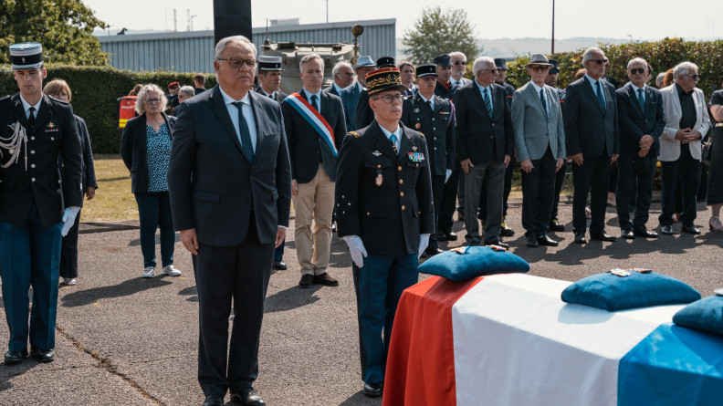 Agrandir l'image le major général de la gendarmerie nationale et un homme en costard à gauche devant un cercueil recouvert du drapeau tricolore