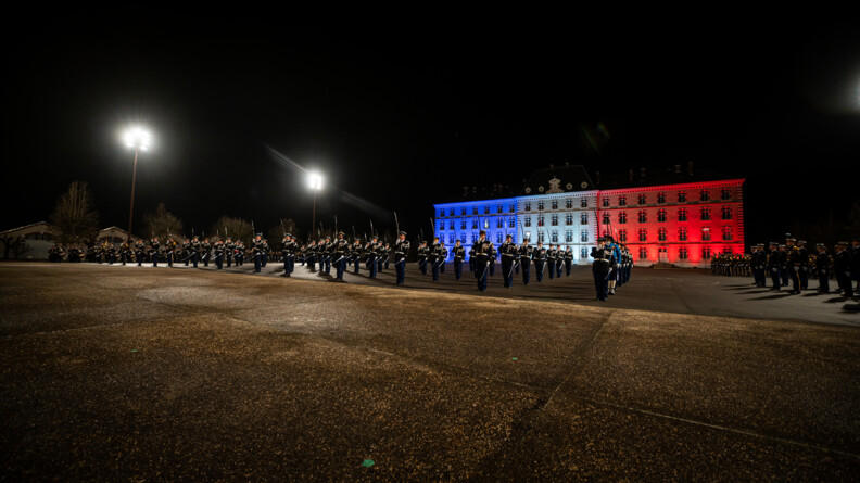 Sur la place d'armes éclairée de bleu-blanc-rouge, 80 officiers issus du rang au présentez sabre