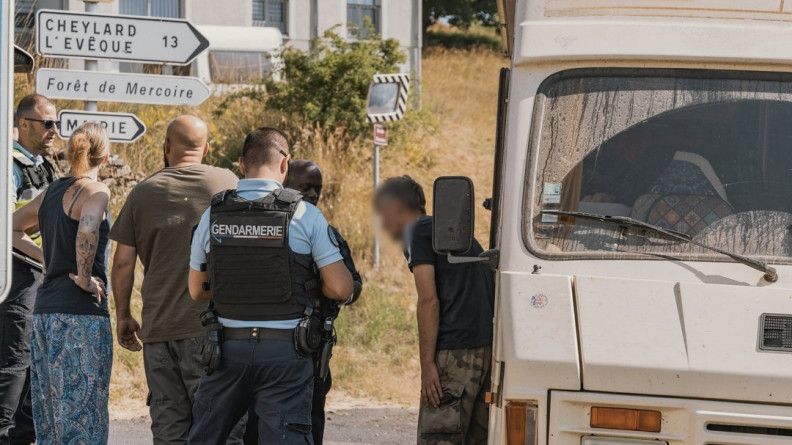 Des gendarmes contrôlent des participants à une rave party. tous se tiennent debout, sur la route, aux côtés d'un vieux van de couleur beige