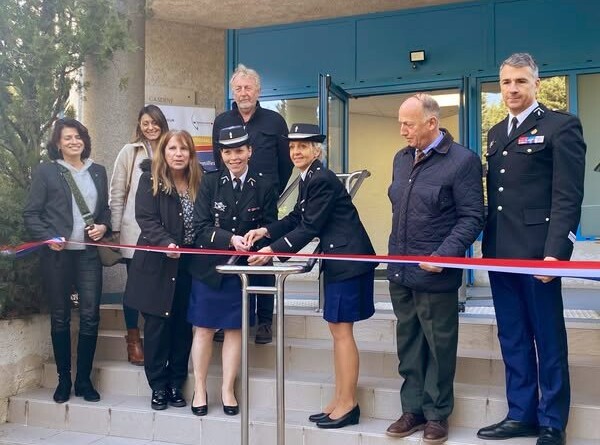Agrandir l'image Deux gendarmes en tenue coupent un ruban inaugural tricolore à l'entrée d'un bâtiment. Elles sont entourées de trois femmes en civil, de deux hommes en civil et d'un officier de gendarmerie.