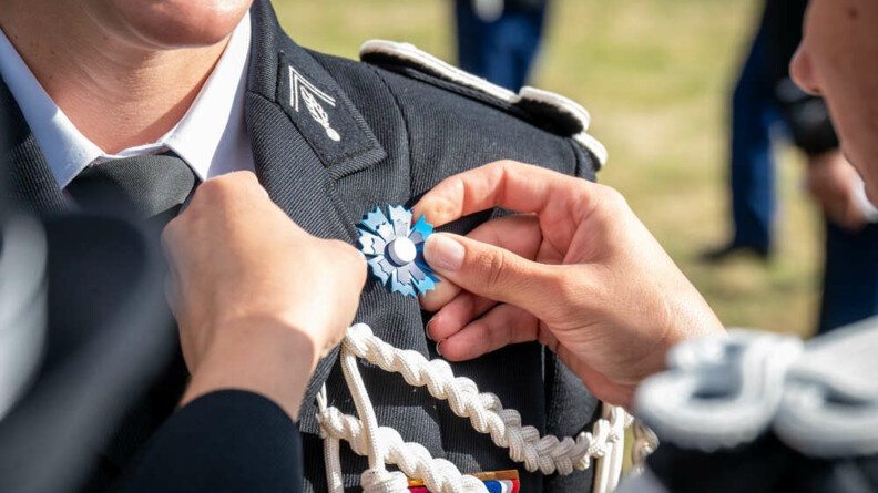 Agrandir l'image Mise en place d'un bleuet de France sur une vareuse gendarmerie par deux élèves