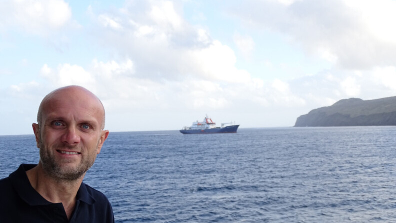 Le major Dufour devant la mer. Au loin on aperçoit le bateau sur lequel il a navigué durant deux mois.