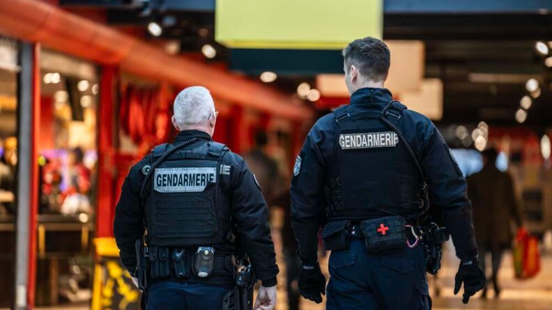 Deux gendarmes mobiles en patrouille, vus de dos