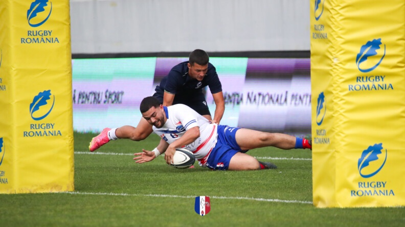 Agrandir l'image Un rugbyman du XV gendarmerie marque un essai derrière les poteaux recouvert de mousse jaune (avec la mention en bleu "Rugby Romania" tandis qu'un jeune rugbyman roumain tente de l'en empêcher