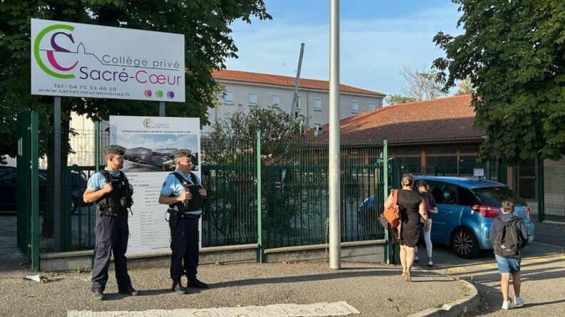 Agrandir l'image Deux gendarmes devant les grilles d'un collège.