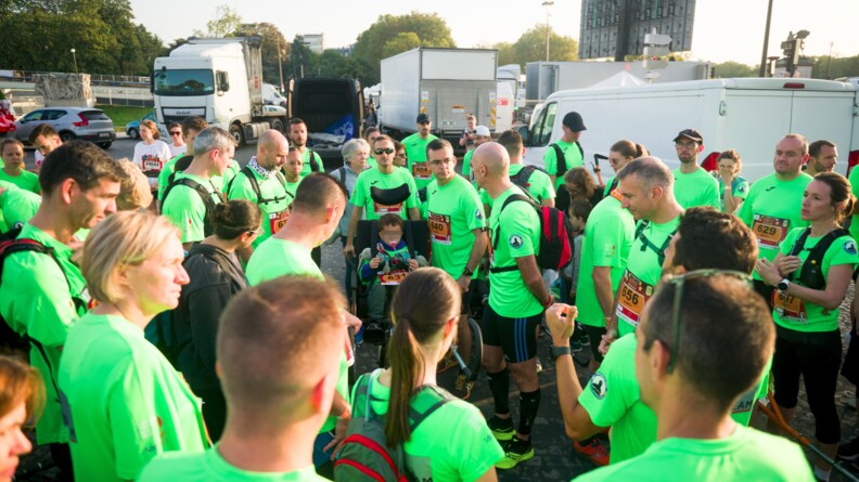 Les coureurs en t-shirt vert fluo entourent un des enfants dans sa joëlette