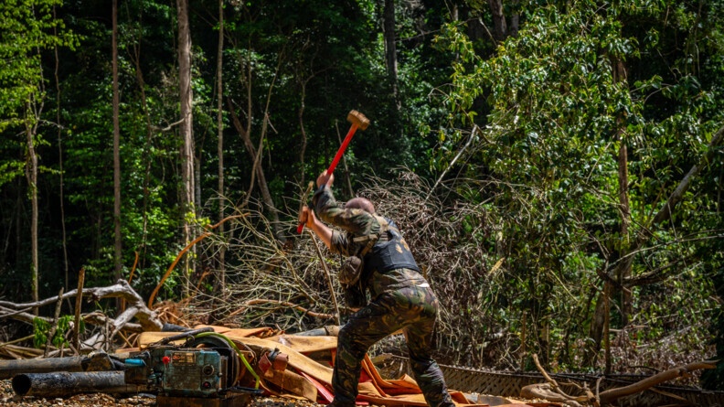 Militaire détruisant un moteur sur un site d'orpaillage.