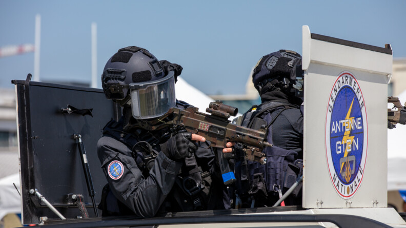 Deux tireurs d'élite de l'antenne GIGN, casqués, prêts à tirer, dans un véhicule blindé.
