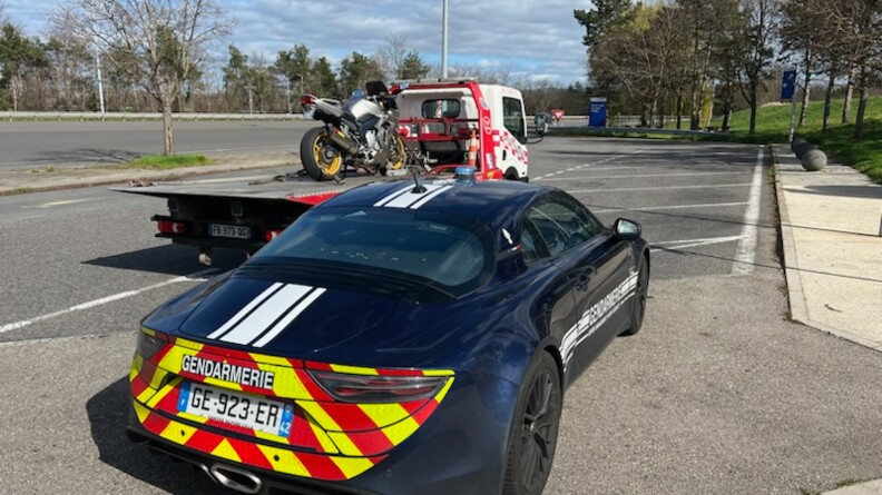 Agrandir l'image Sur un parking devant une alpine vue de dos un camion embarque une moto