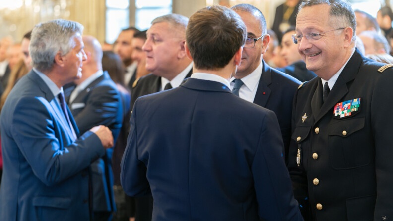 Le pr&eacute;sident de la R&eacute;publique, de dos, &eacute;change avec le g&eacute;n&eacute;ral d'arm&eacute;e Christian Rodriguez, &agrave; droite, et le pr&eacute;fet de police de Paris, &agrave; gauche. A gauche de l'image, en arri&egrave;re-plan, le directeur des op&eacute;rations et de l'emploi &eacute;change avec un homme en costume bleu.