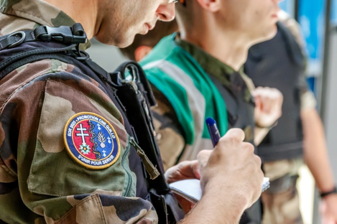 Agrandir l'image La photo représente l'épaule d'un militaire vêtu d'une tenue camouflage, avec un écusson sur la manche "EOR 2025 - Promotion Guillo - S'unir pour servir "