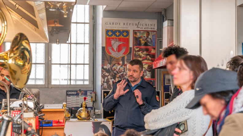 Le casquier de la Garde républicaine reçoit des visiteurs dans son atelier