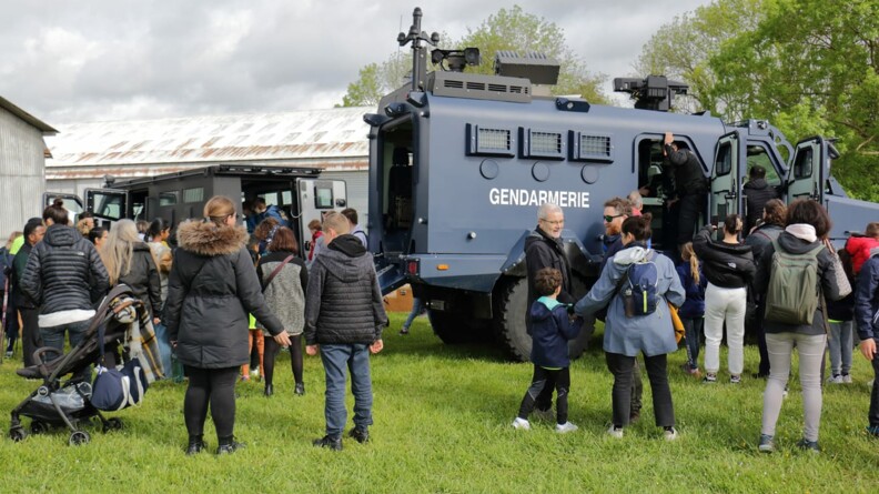 Agrandir l'image Des familles au pied d'un Centaure et d'un blindé police