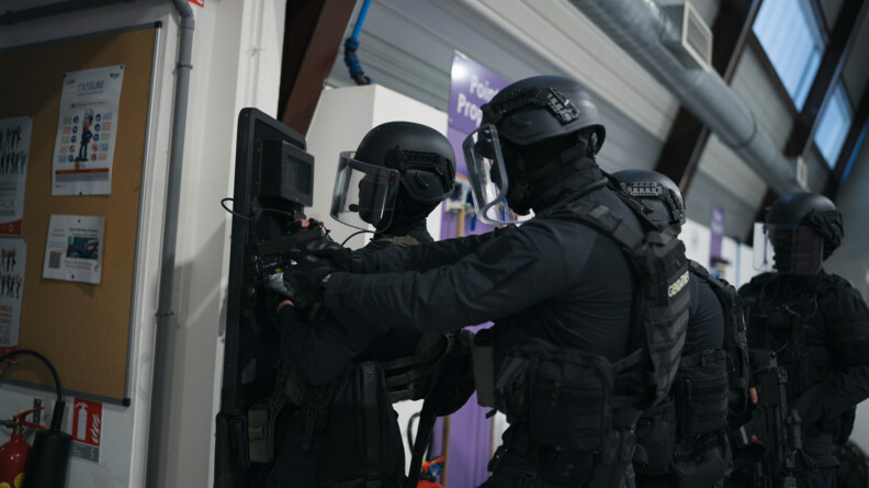 Photo en couleur et en intérieur de la progression de quatre militaires du PSPG.