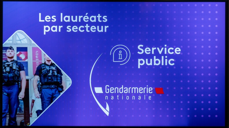 Agrandir l'image Sur un écran bleu, avec à gauche une image en forme de losange où l'on voit des gendarmes, avec les mentions en blanc, de haut en bas "les lauréats par secteur", "service public", "gendarmerie nationale"