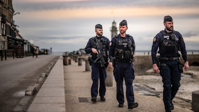 Agrandir l'image Trois gendarmes patrouillent le long de la jetée