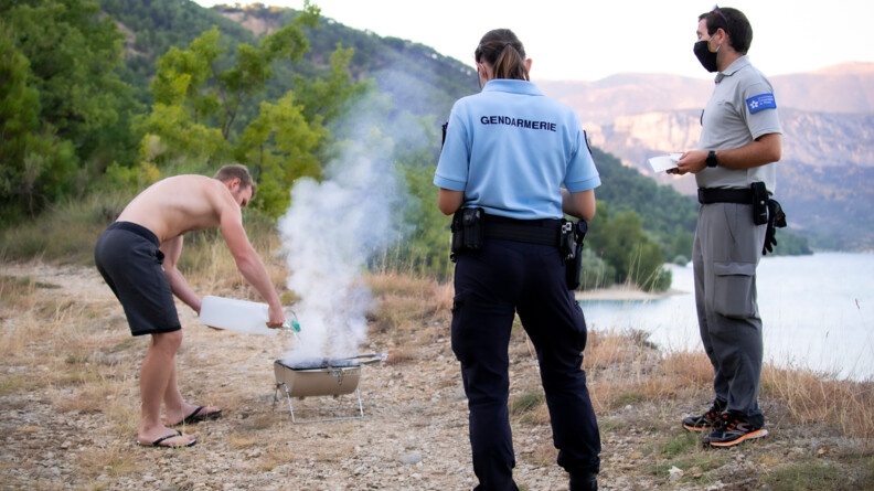 Pour prévenir tout risque d'incendie, les barbecues sont totalement interdits. Julie, gendarme du poste provisoire de Sainte-Croix-du-Verdon verbalise le contrevenant et le contraint à éteindre les braises.