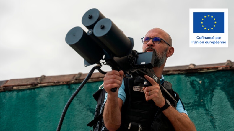 Agrandir l'image Un gendarme debout face à nous tenant un fusil anti-drone