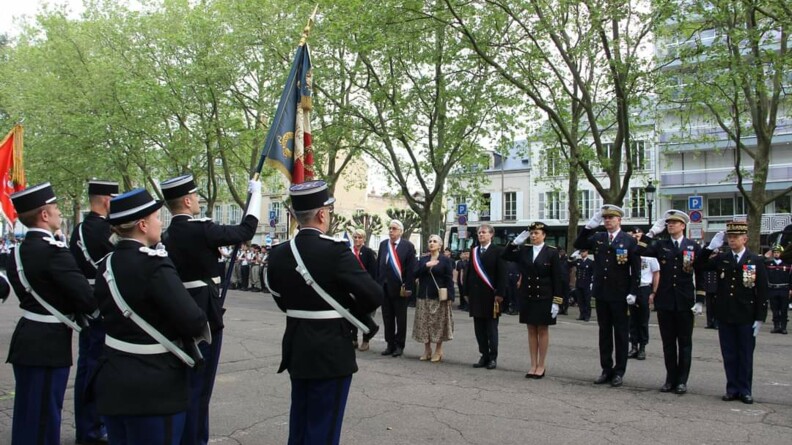 Les autorités militaires et civiles alignées sur une place saluent le drapeau.