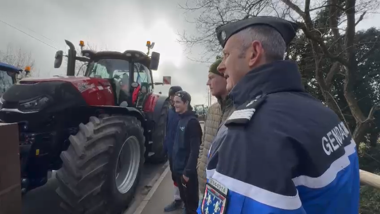Un chef d'escadron échangent avec des agriculteurs sur la route en extérieur.