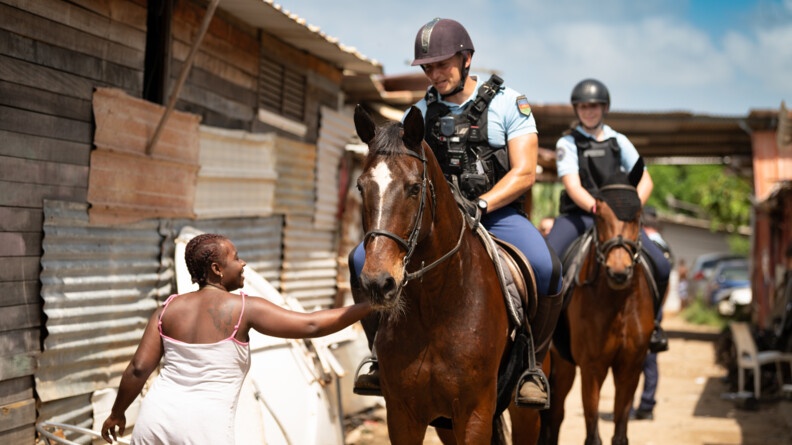 Agrandir l'image Habitante d'un quartier informel caressant le cheval du groupe équestre.