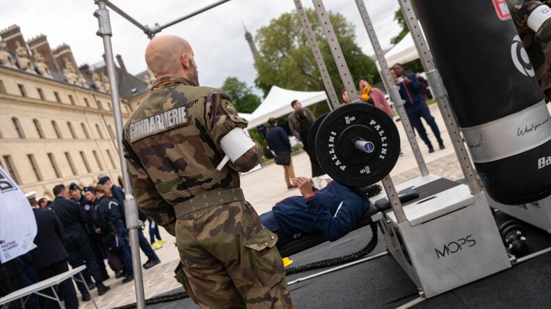 Un SHND d'une arm&eacute;e teste le parcours sportif, le d&eacute;velopp&eacute; couch&eacute; &agrave; la barre, devant les Invalides