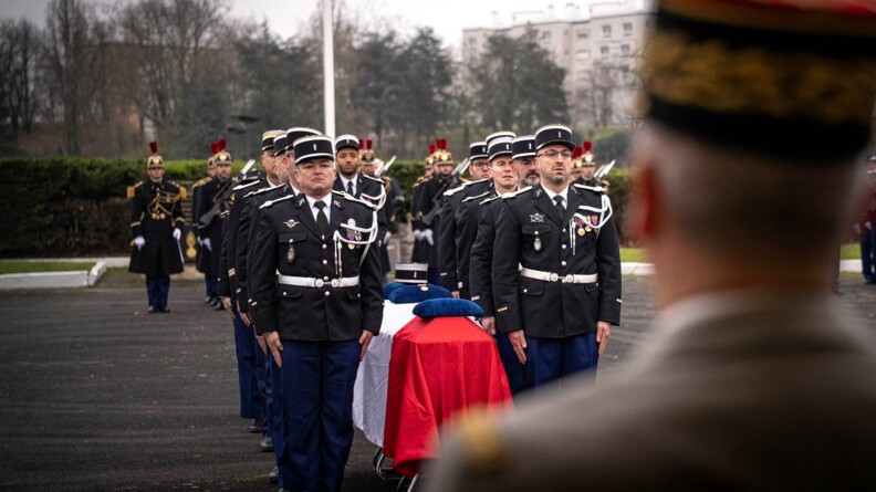 En amorce un gendarme, derri&egrave;re le cercueil entour&eacute; d'autres gendarmes au garde &agrave; vous.