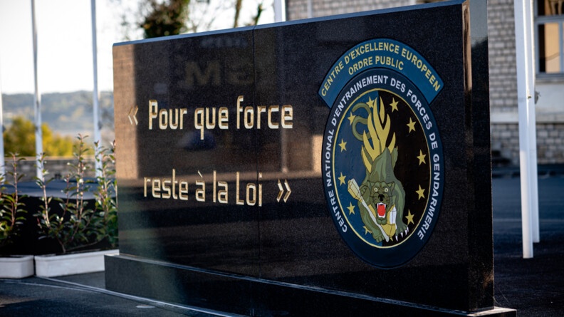 Gros plan sur une stèle noire avec le logo du Central national d'entraînement des forces gendarmerie et sa devise "Pour que force reste à la loi"