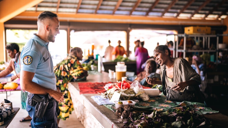Gendarme échangeant avec une commerçante au marché de Lifou.