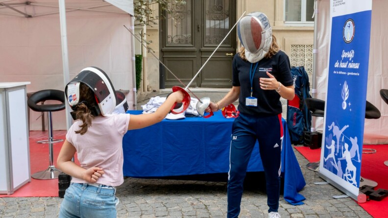 Agrandir l'image Une jeune fille s'essaye à l'escrime avec une sportive de haut niveau de la Défense - gendarmerie.
