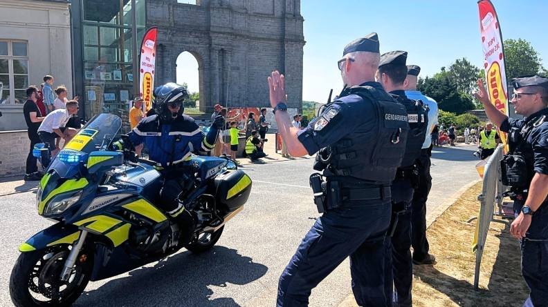 Motocyclistes de la gendarmerie nationale ouvrant l'itinéraire et saluant ses camarades gendarmes en bord de route.