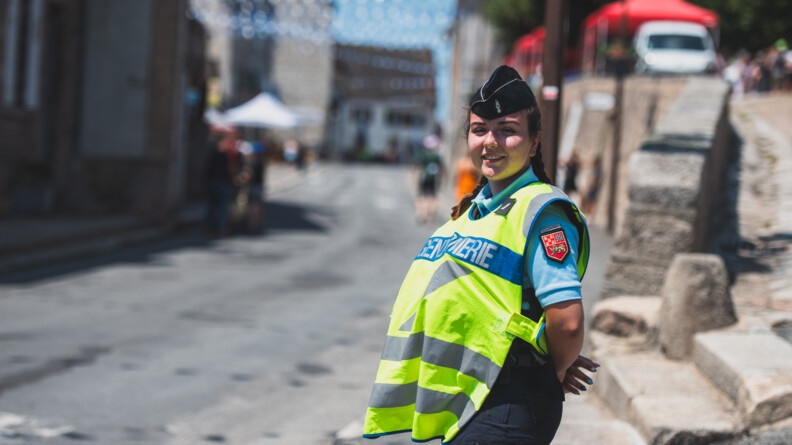 Une gendarme départementale d'une brigade de la Creuse avec une chasuble gendarmerie, sécurise l'axe sur lequel va passer les courreurs