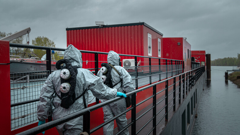 Agrandir l'image 2 opérateurs de la F2NRBC progressent en combinaise sur la péniche contaminée