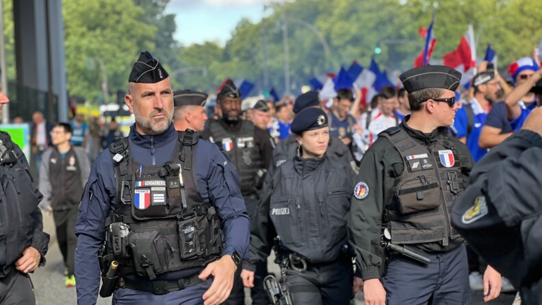 Une patrouille de gendarmes français et policiers allemands de l'UOFA au milieu des supporters brandissant des drapeaux