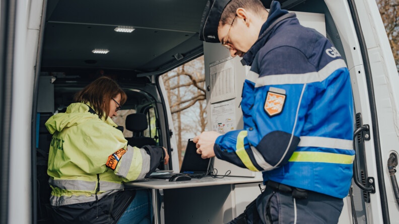 Un gendarme dans un v&eacute;hicule regarde un permis de conduire.