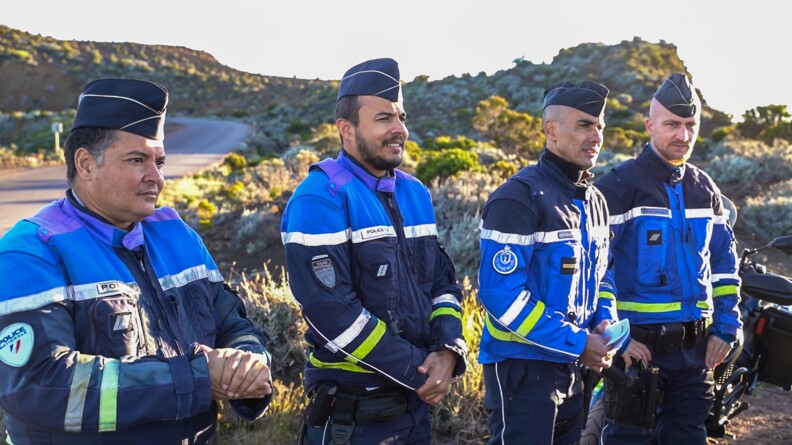 En ligne quatre gendarmes regardent la route.