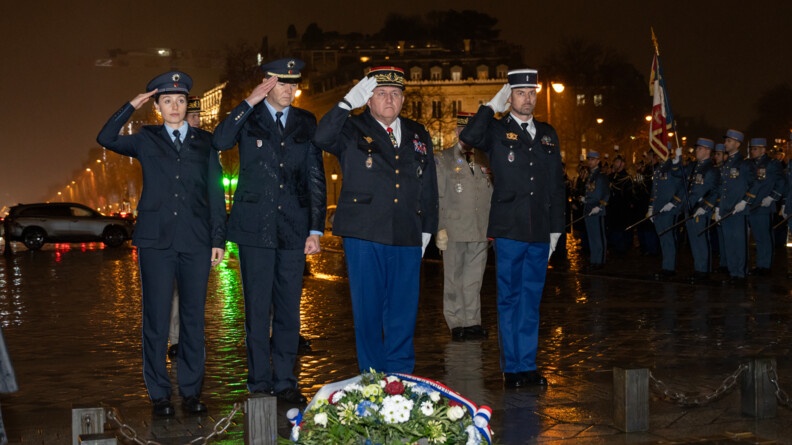 Deux policiers allemands et deux gendarmes fran&ccedil;ais dont un g&eacute;n&eacute;ral saluent militairement. A droite en arri&egrave;re-plan, des militaires. La nuit et la pluie sont sur la ville