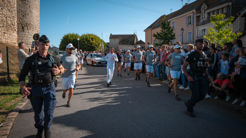 Deux gendarmes à pied sécurisent le Relais de la flamme paralympique.