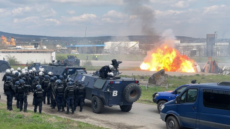 Une vingtaine de gendarme de la FGE en tenue de maintien de l'ordre, derri&egrave;re des fourgons blind&eacute;s, pr&egrave;s d'une sc&egrave;ne d'explosion
