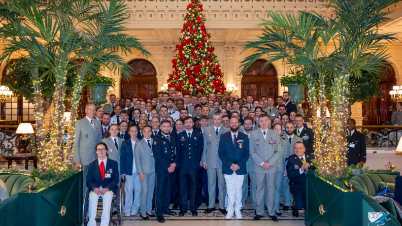 Une centaine de sportifs de haut niveau de la D&eacute;fense, athl&egrave;tes et para-athl&egrave;tes, en vareuse ou en tenue civile, posent au pied d'un sapin de No&euml;l, dans le hall d'un grand h&ocirc;tel parisien.