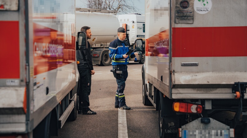 Un gendarme et un agent des douanes controlent une camionnette.