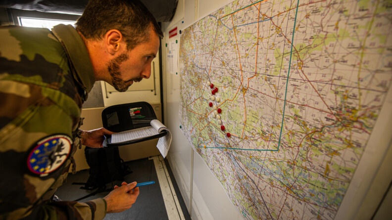 Un élèves-officiers à gauche, en train de planifier la manoeuvre avec une carte