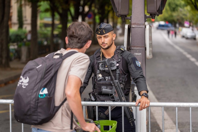 Agrandir l'image Un gendarme mobile discute avec un passant (on aperçoit ce dernier de dos)