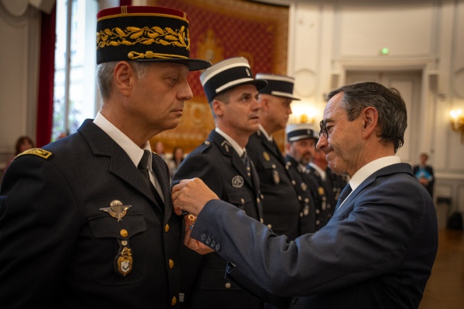 Agrandir l'image Le ministre de l'Intérieur, Bruno Retailleau, décore un gendarme de la médaille du Mérite.
